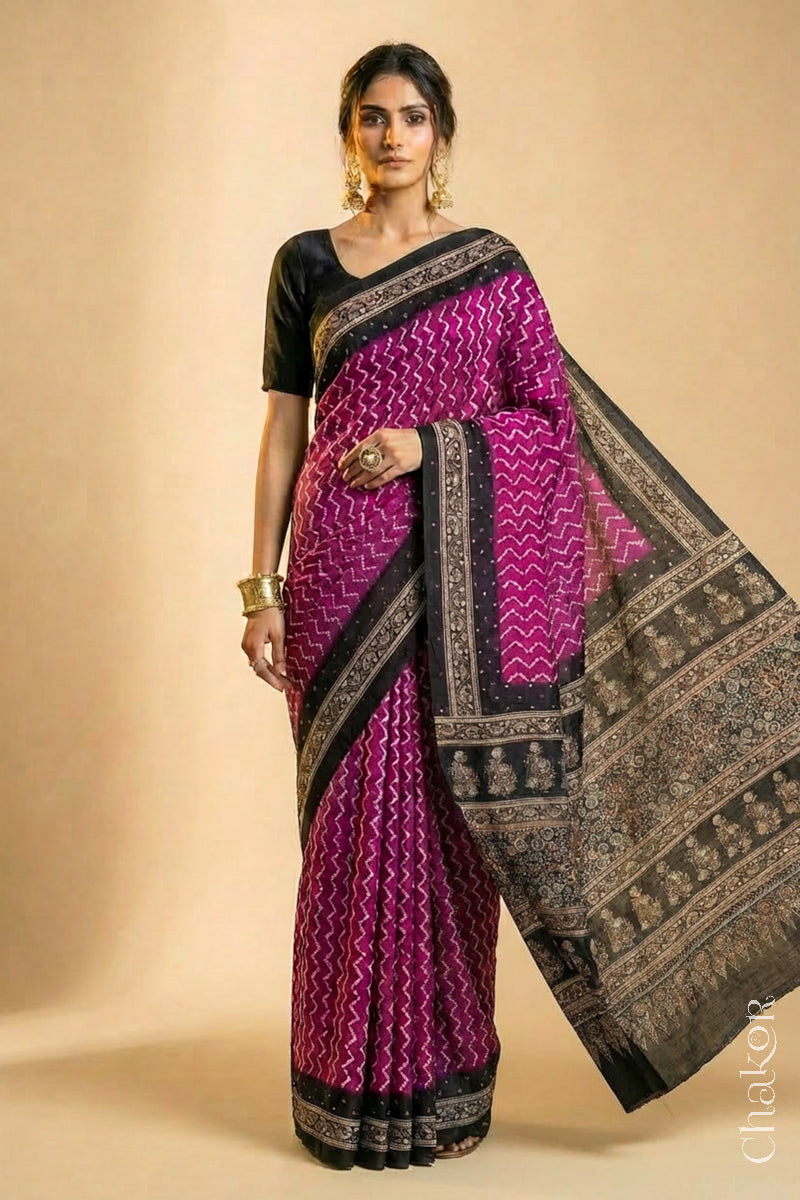 Woman wearing Magenta Bandhani Saree with Black Ajrakh printed border and pallu in pure gaji silk with traditional bandhej tie-dye & mirror work, handcrafted in Kutch.
