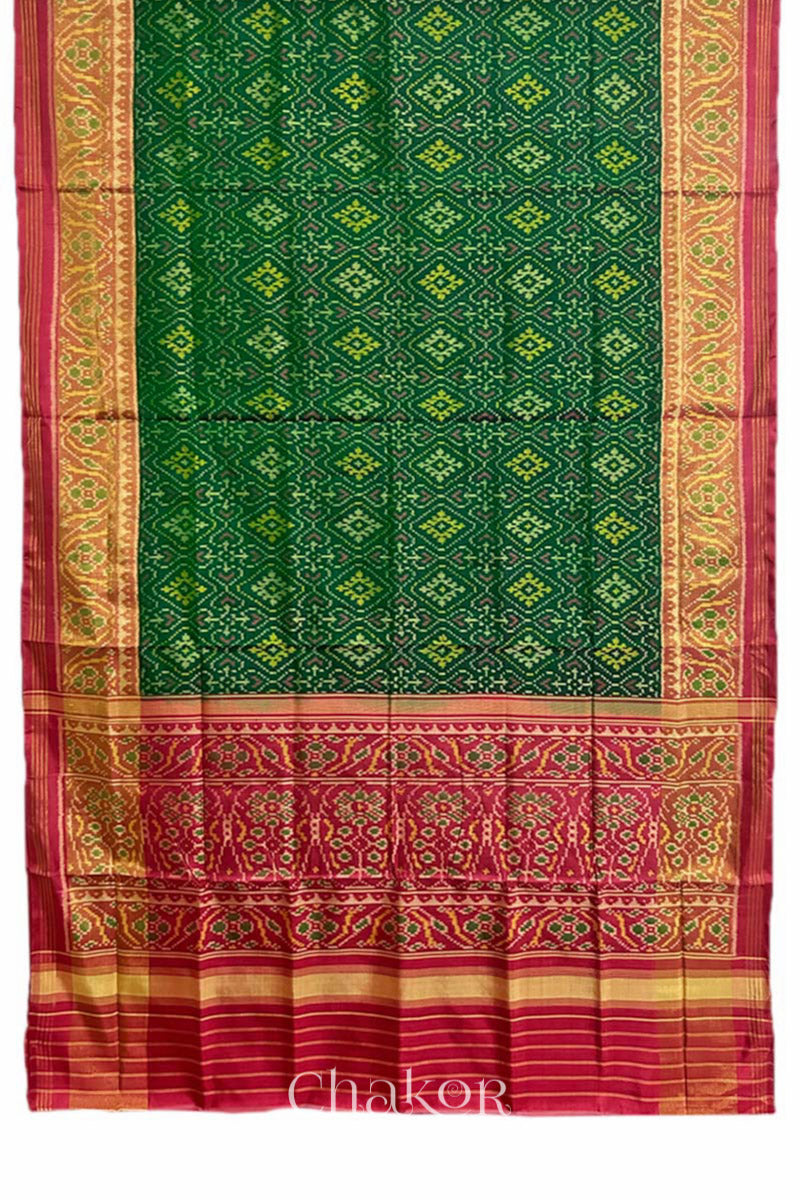 Full view of Handloom Green Rajkoti Patola Ikat Mulberry Silk Saree with red border pallu, woven using traditional designs in Gujarat.