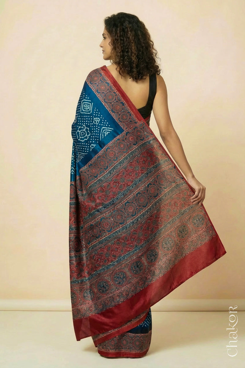 Woman wearing Navy Bandhani Saree with Red Ajrakh printed border and pallu in pure gaji silk with traditional bandhej tie-dye, handcrafted in Kutch.