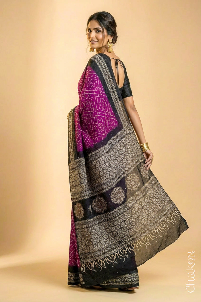 Woman wearing Magenta Bandhani Saree with Natural Black Ajrakh printed border and pallu in pure gaji silk with traditional bandhej tie-dye & mukaish embroidery, handcrafted in Kutch.