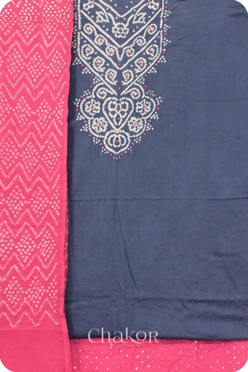 A blue grey kurta set fabric with intricate white bandhani & mirror embroidery, paired with a pink bottom & odhani featuring a zigzag design.