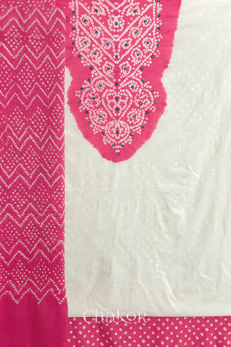 A pink- white kurta set fabric with intricate bandhani & mirror embroidery, paired with a pink bottom & odhani featuring a zigzag design.