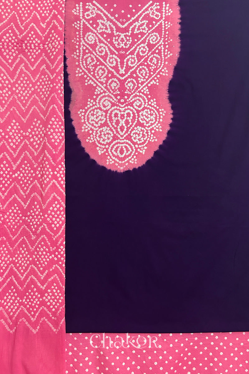 A dark purple kurta set fabric with intricate bandhani & pink yoke with sparkly mukaish embroidery, paired with a bottom & odhani placed on the left side featuring a zigzag design.
