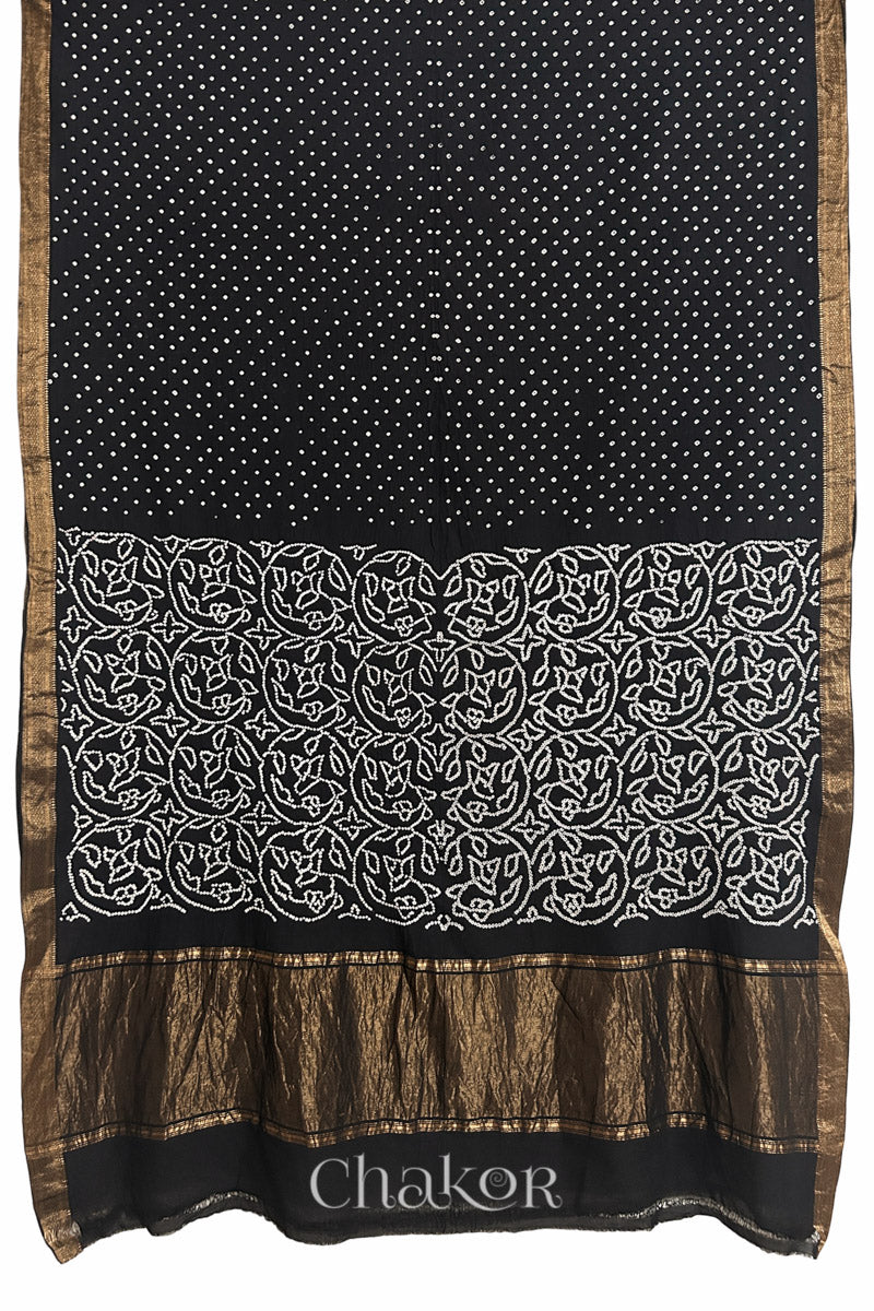 Black saree, flat draped with Rai Bandhej traditional design against white background and 'Chakor' watermark.