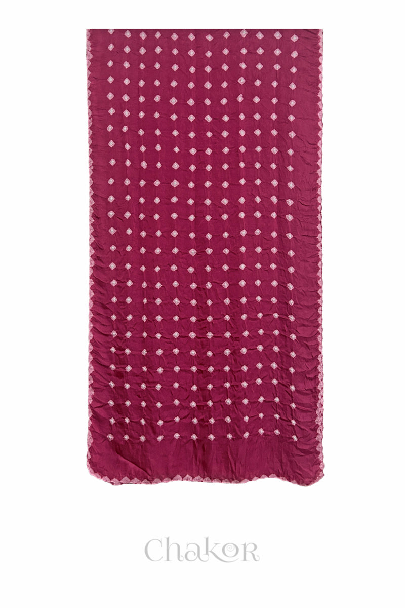 Flat view of raspberry pink Bandhani modal stole showing evenly spaced tie-dye pattern.