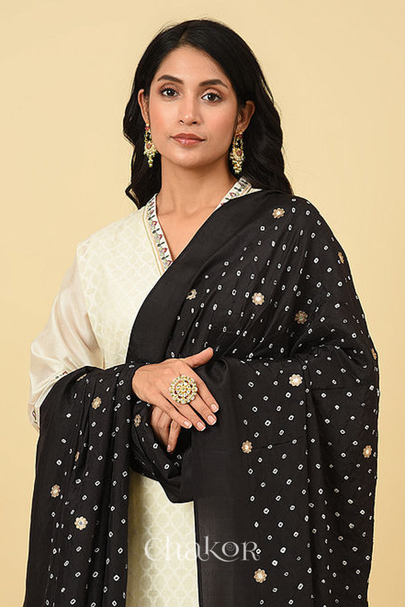 Close up of model wearing Black Bandhani Mulberry silk dupatta with sequins embroidery and bead edging over a off-white kurta.