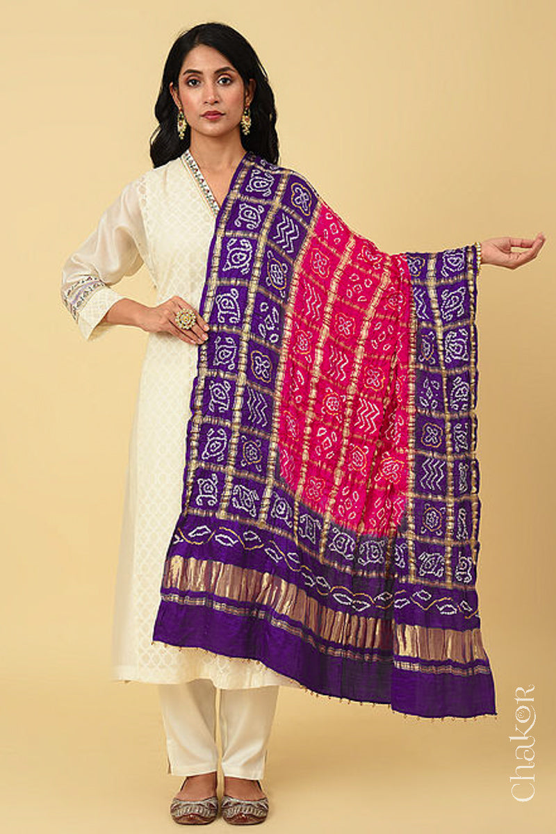 Full view of woman wearing Pink Purple Bandhani Gharchola Gaji Silk Dupatta on beige kurta set.
