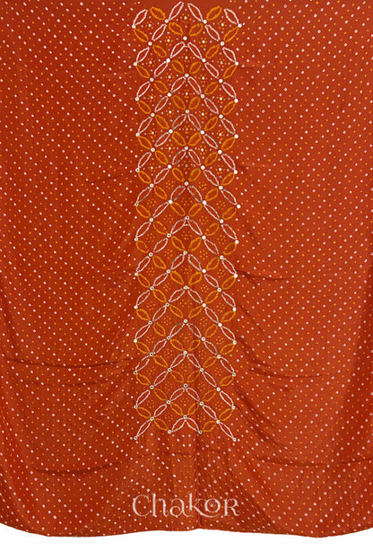 Full fabric panel of Rusty Orange mulberry silk Bandhani (Rai Bandhej) with all-over white dots and a floral border with golden zari mirror & sequins embroidery – CHAKOR.

