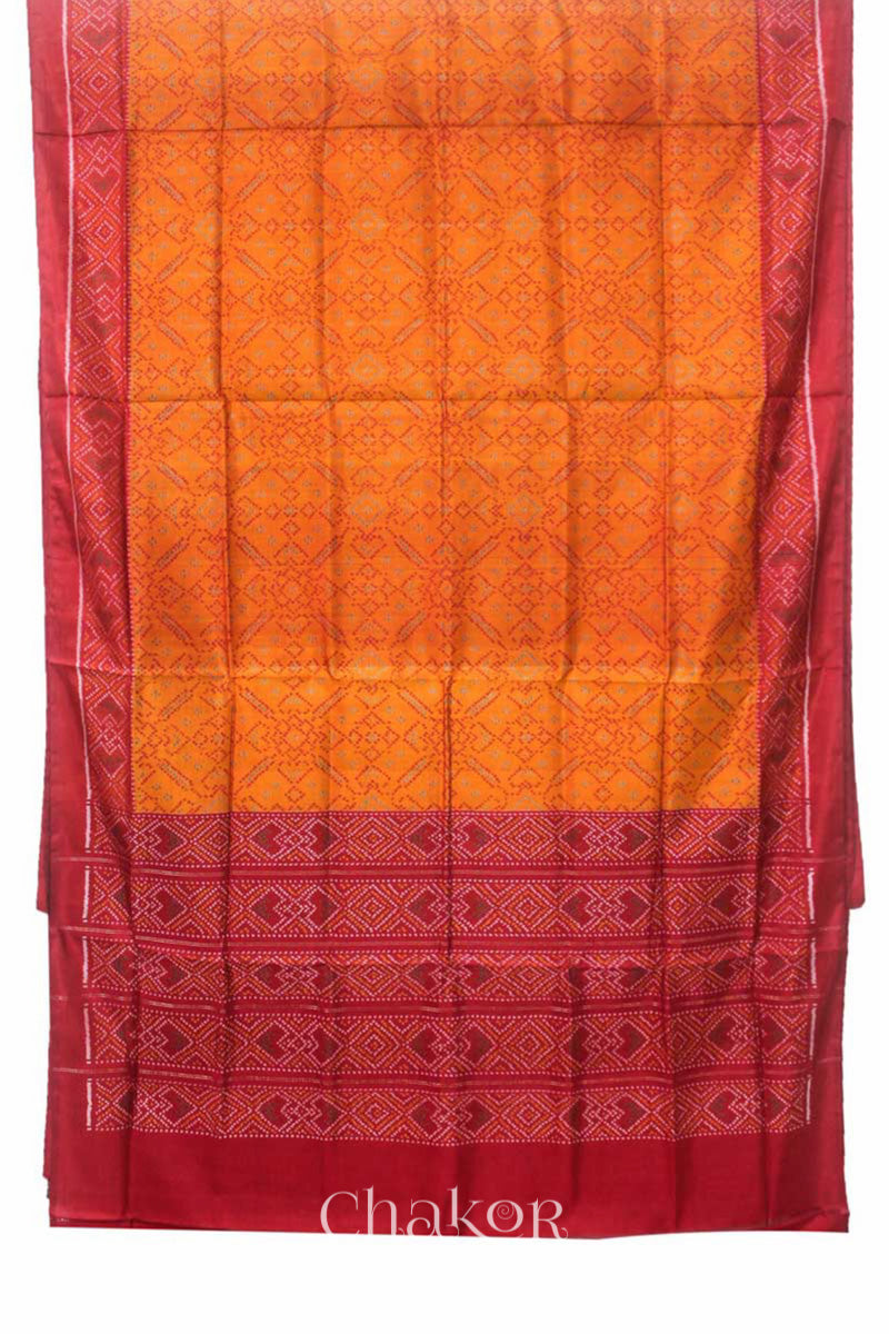 Full view of Handloom Orange Rajkoti Patola Ikat Mulberry Silk Saree with red borders pallu, woven using traditional designs in Gujarat.