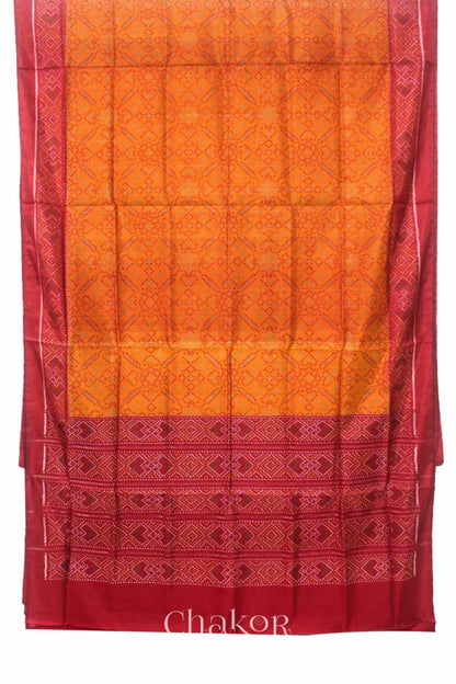 Full view of Handloom Orange Rajkoti Patola Ikat Mulberry Silk Saree with red borders pallu, woven using traditional designs in Gujarat.
