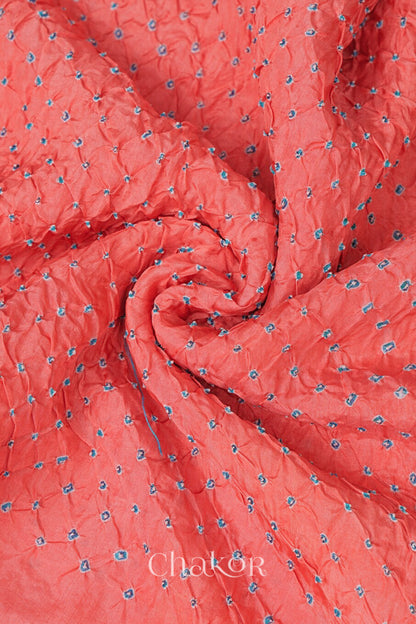 Close up of peach Bandhani mulberry silk dupatta with tie-dye dot pattern & detailed with golden lace.