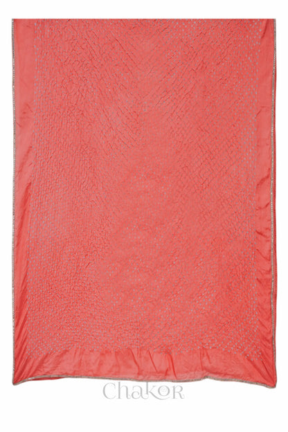 Close up of peach Bandhani mulberry silk dupatta with tie-dye dot pattern & detailed with golden lace.