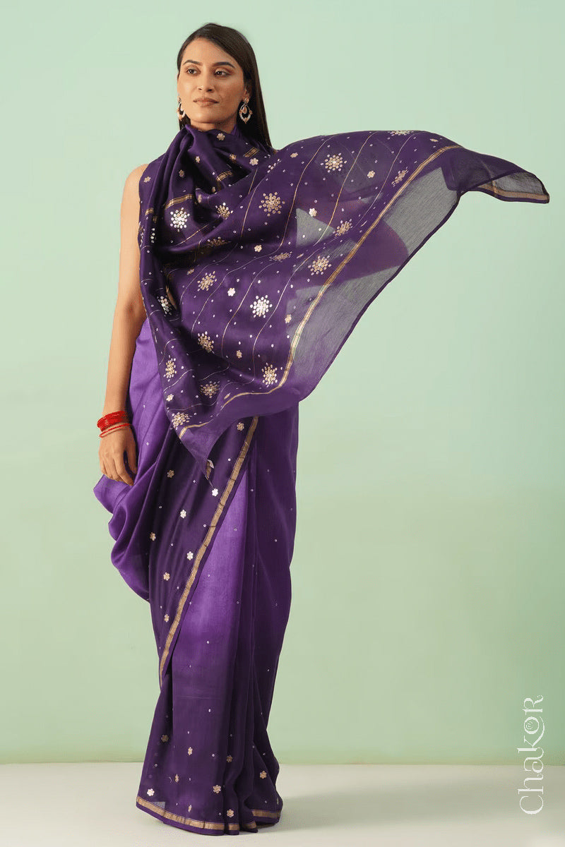 Model wearing a violet purple shaded Chanderi silk cotton saree with hand-embroidered sequin and zari details.
