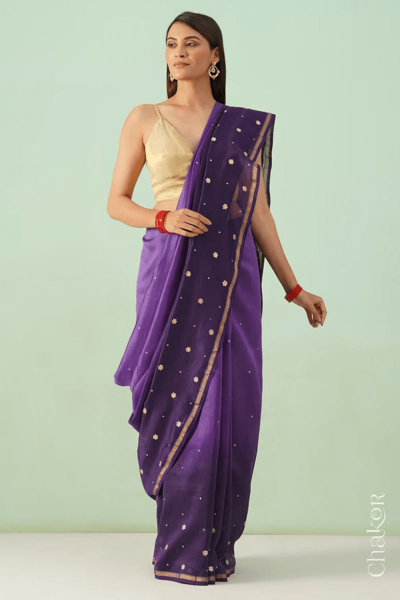 Model standing in violet purple shaded Chanderi silk cotton saree highlighting the handloom drape.
