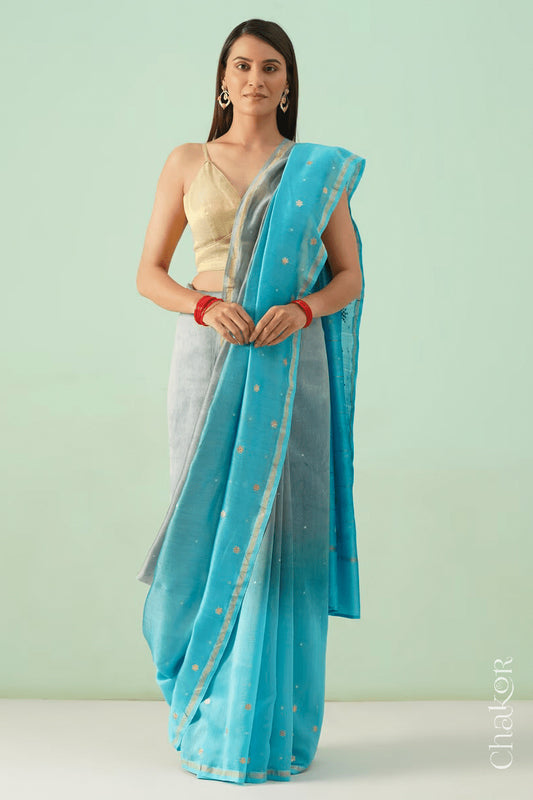 Model wearing a grey blue shaded Chanderi silk cotton saree with hand-embroidered sequin and zari details.
