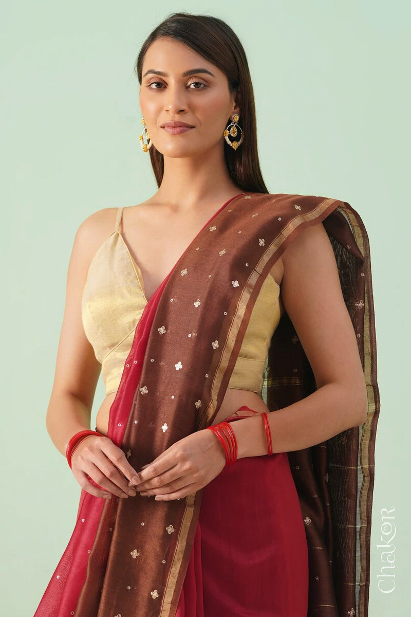 Front close view of red brown shaded Chanderi silk cotton saree showing woven body and embroidered details.
