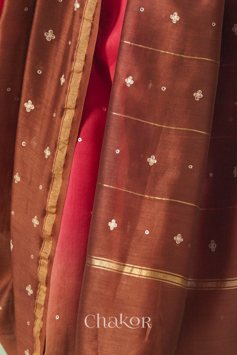 Close-up of hand-embroidered sequin and zari work on red brown Chanderi silk cotton saree.
