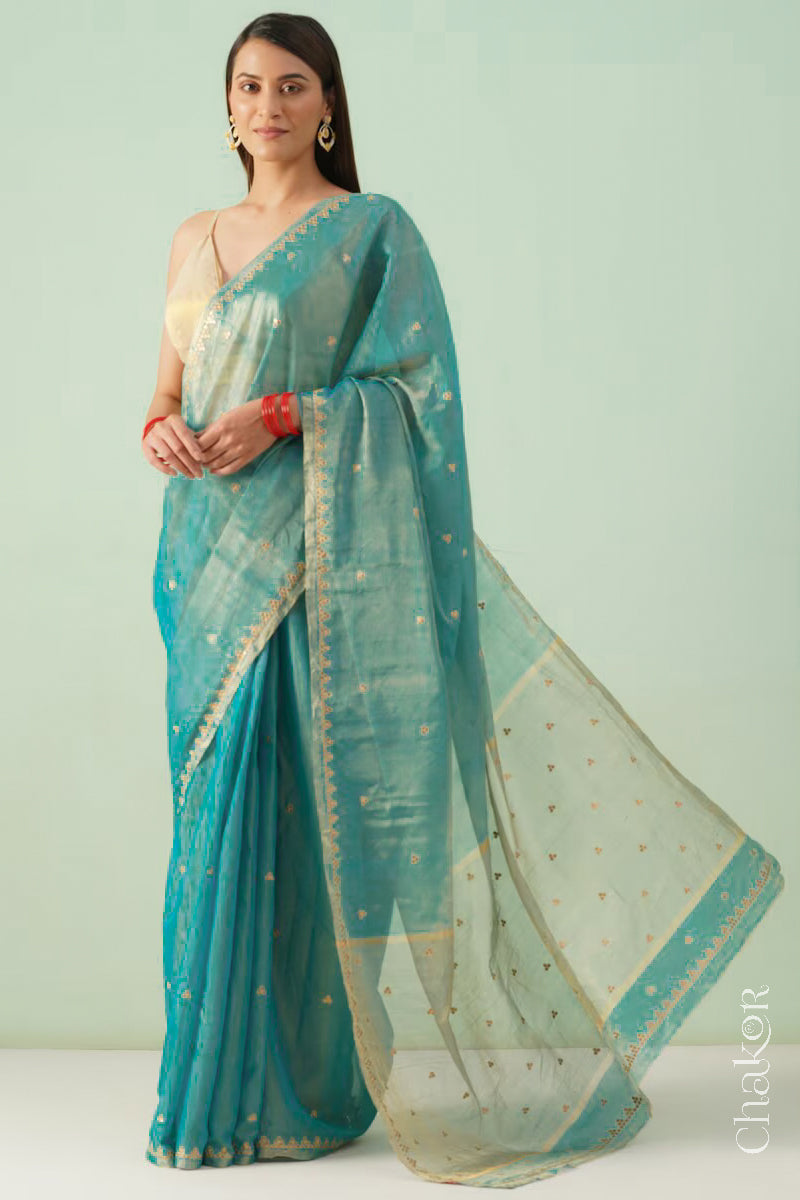 Model wearing a peacock blue Chanderi tissue silk cotton saree with hand-embroidered sequin and zari details.
