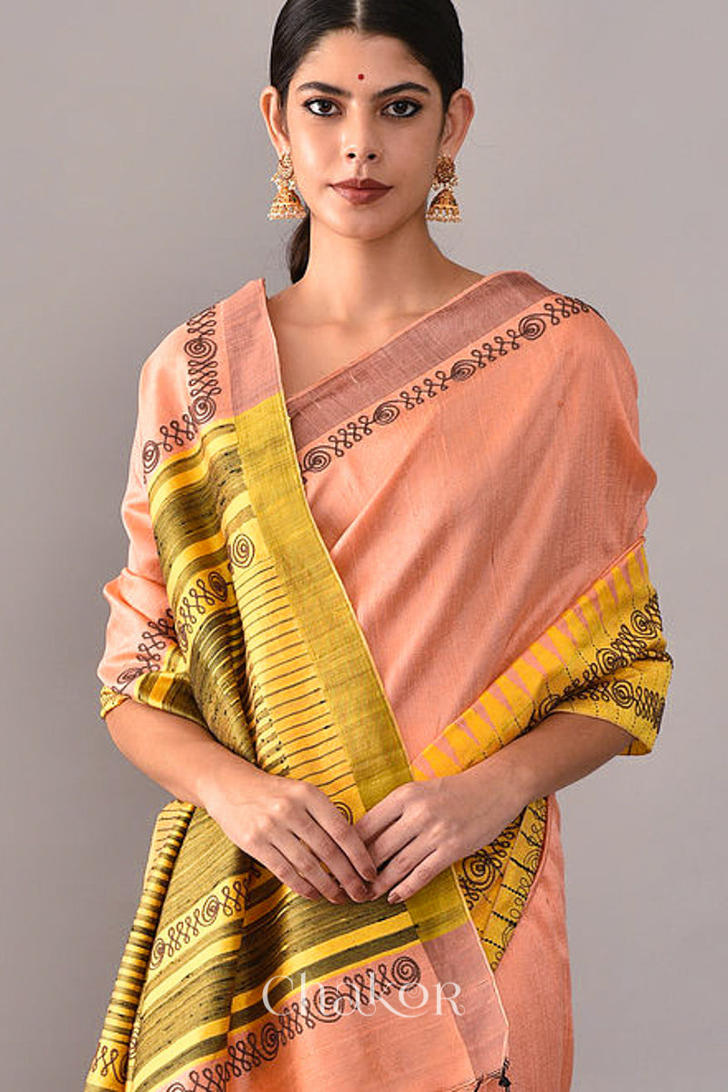 Woman wearing a Peach Yellow Raw Tussar silk handloom saree with Yellow border and detailed with aari embroidery