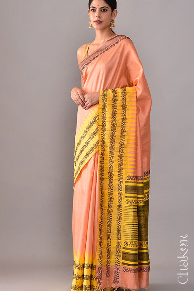 Woman wearing a Peach Yellow Raw Tussar silk handloom saree with Yellow border and detailed with aari embroidery
