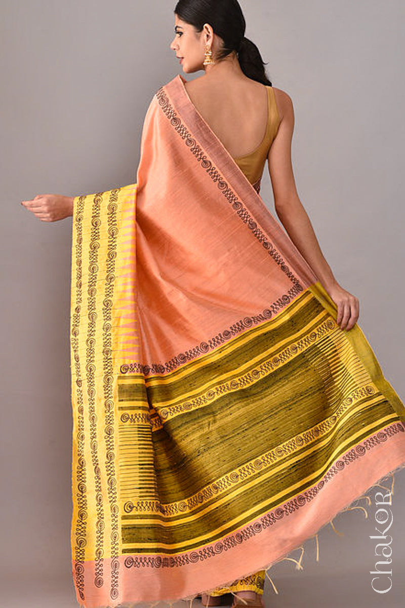 Back Pose of Woman wearing a Peach Yellow Raw Tussar silk handloom saree with Yellow border and detailed with aari embroidery