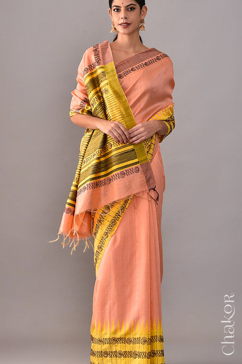 Woman wearing a Peach Yellow Raw Tussar silk handloom saree with Yellow border and detailed with aari embroidery