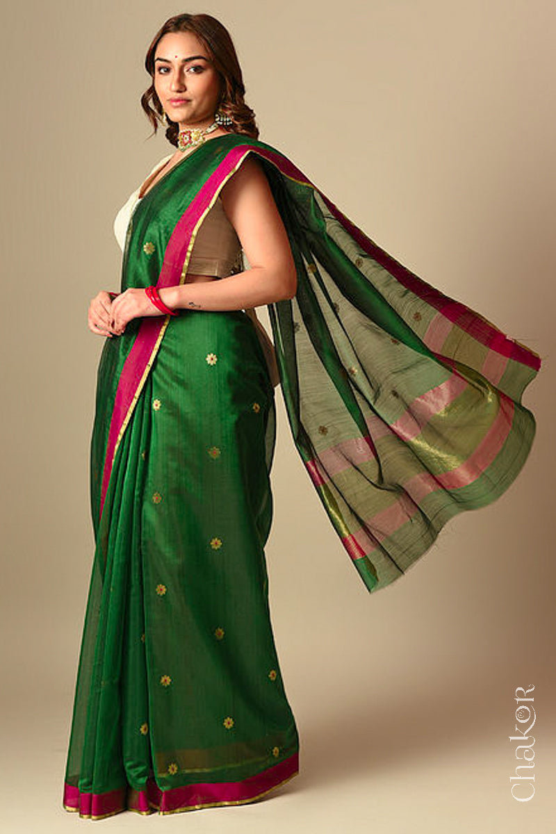 Model wearing a green Chanderi silk cotton saree with Ganga Jamuna borders and tissue-striped pallu.
