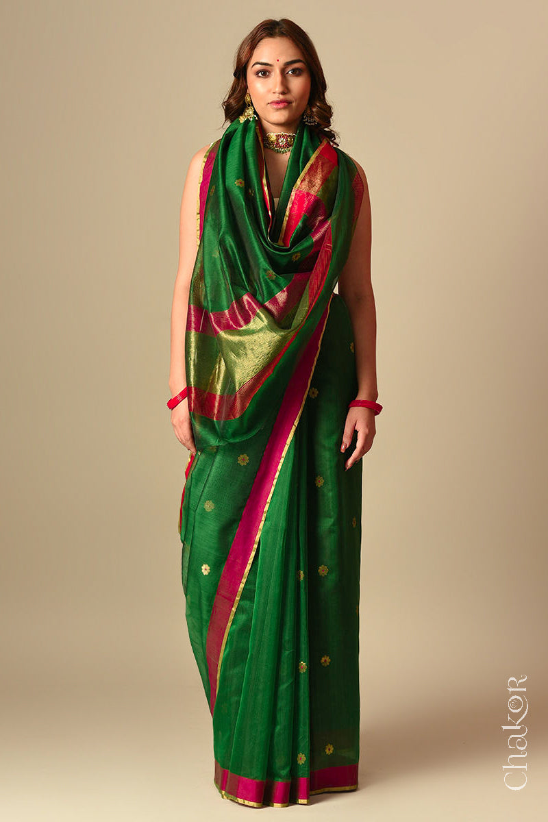 Model wearing a green Chanderi silk cotton saree with Ganga Jamuna borders and tissue-striped pallu.
