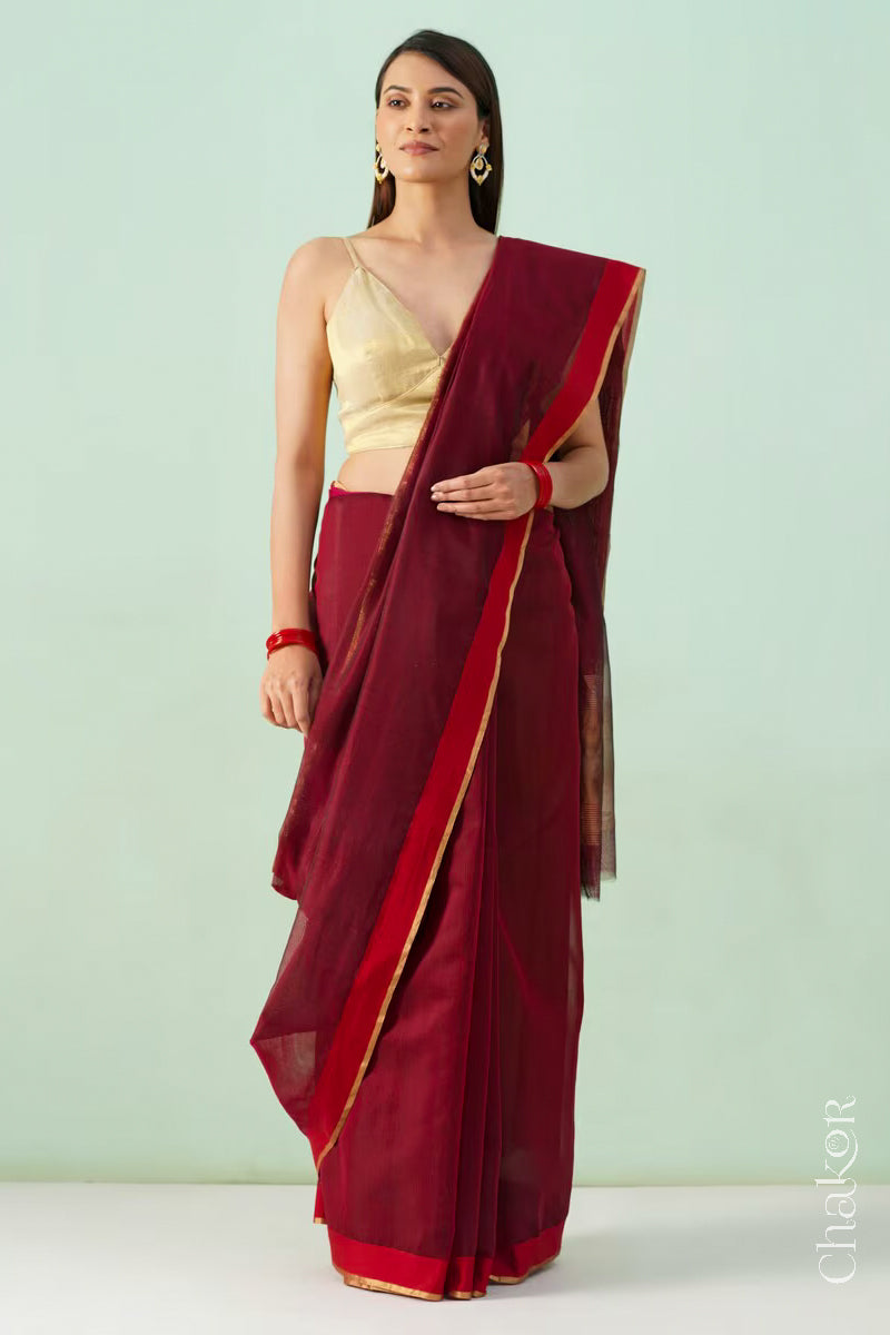 Model wearing a Maroon Chanderi silk cotton saree with tissue pallu and Ganga Jamuna borders, handwoven in Chanderi.
