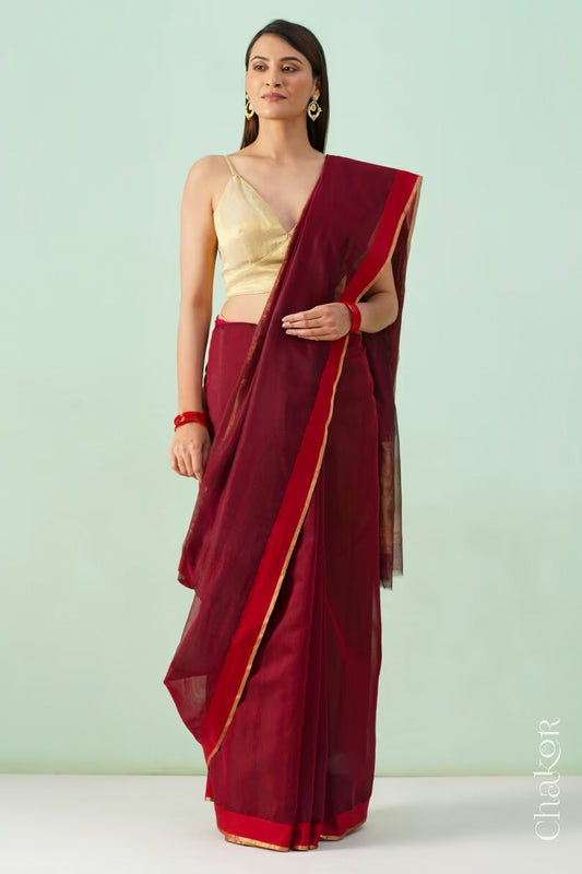 Model wearing a Maroon Chanderi silk cotton saree with tissue pallu and Ganga Jamuna borders, handwoven in Chanderi.
