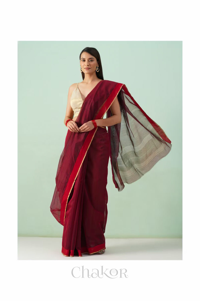 Model wearing a Maroon Chanderi silk cotton saree with tissue pallu and Ganga Jamuna borders, handwoven in Chanderi.
