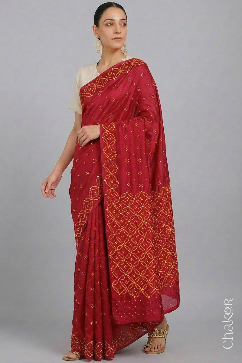 Model wearing Red Bandhani Mulberry Silk Saree handcrafted with yellow bandhej dots and mirror embroidery.