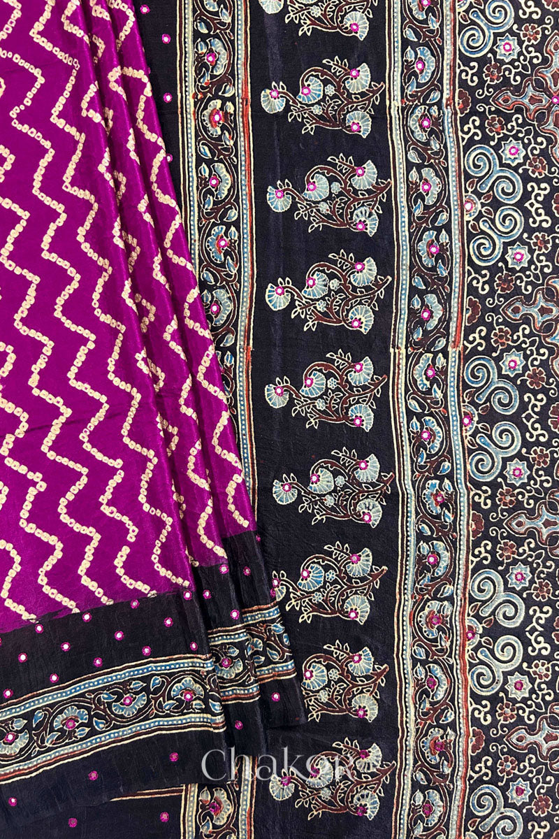 Close up of Magenta Bandhani Saree with Black Ajrakh printed border and pallu in pure gaji silk with traditional bandhej tie-dye & mirror work, handcrafted in Kutch. 