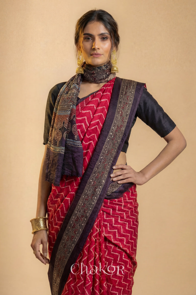 Woman wearing Red Bandhani Saree with Black Ajrakh printed border and pallu in pure gaji silk with traditional bandhej tie-dye, handcrafted in Kutch. 