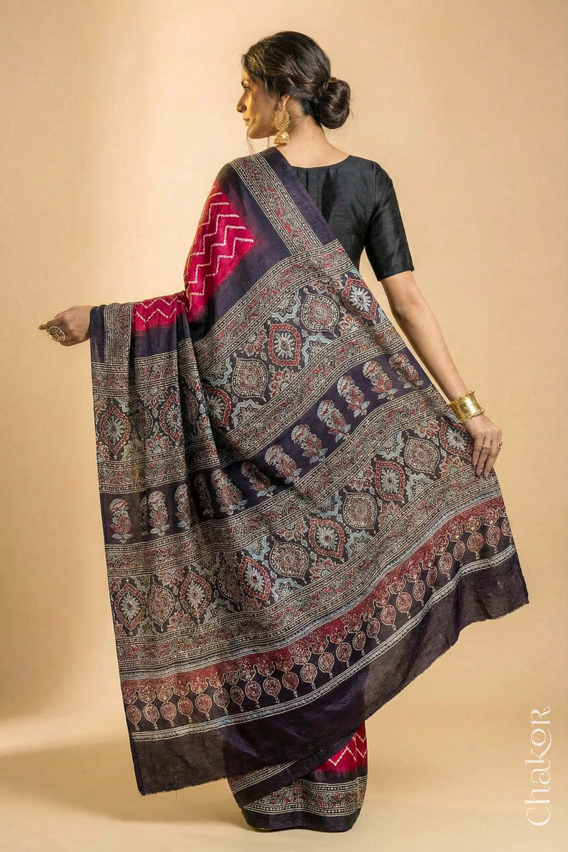 Woman wearing Red Bandhani Saree with Black Ajrakh printed border and pallu in pure gaji silk with traditional bandhej tie-dye, handcrafted in Kutch. 