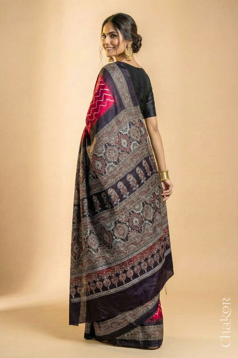 Woman wearing Red Bandhani Saree with Black Ajrakh printed border and pallu in pure gaji silk with traditional bandhej tie-dye, handcrafted in Kutch. 