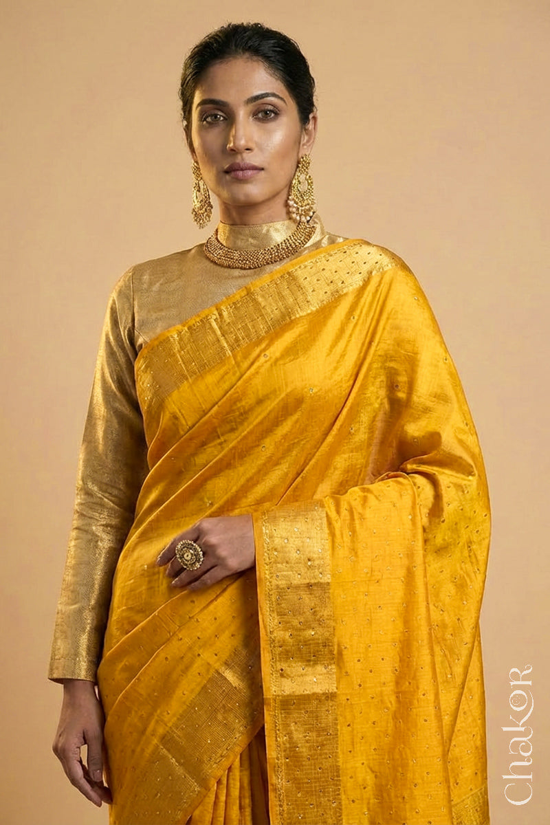 Woman wearing a Yellow tussar silk handloom saree with golden zari border & hand embroidered with  sequins & zari work