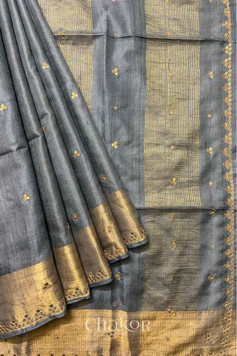 Close up of Grey tussar silk handloom saree with golden zari border & hand embroidered with  sequins & zari work