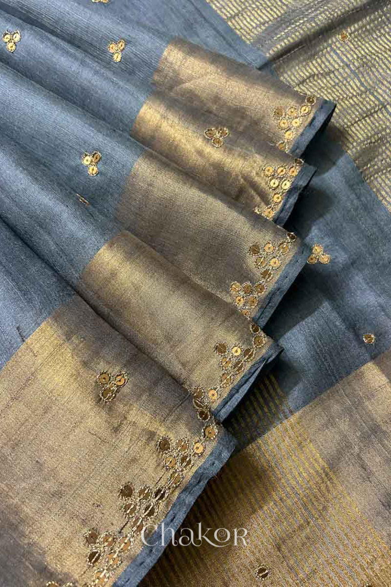 Close up of Grey tussar silk handloom saree with golden zari border & hand embroidered with  sequins & zari work