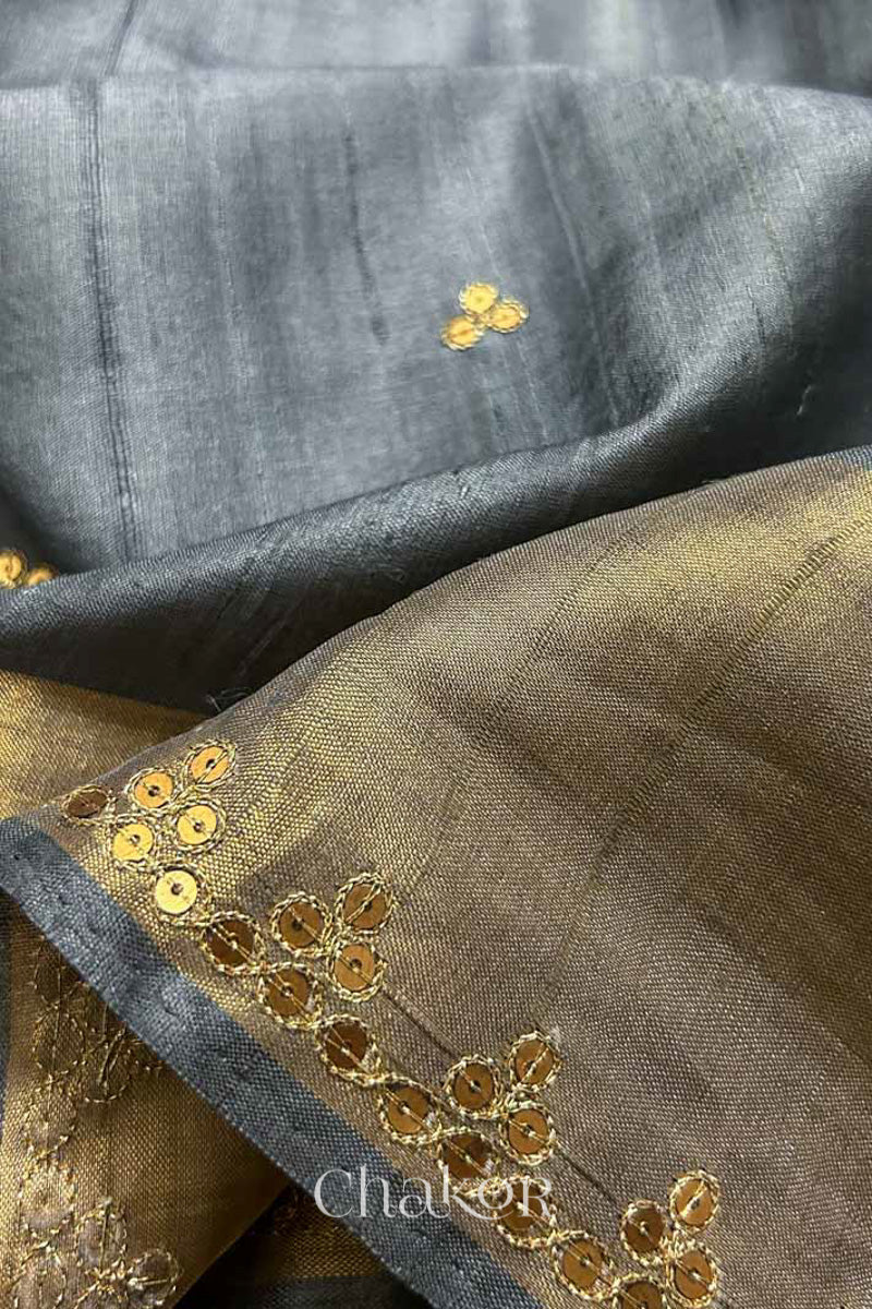Close up of Grey tussar silk handloom saree with golden zari border & hand embroidered with  sequins & zari work