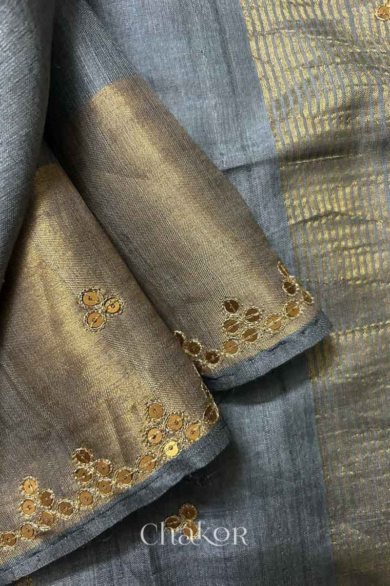 Close up of Grey tussar silk handloom saree with golden zari border & hand embroidered with  sequins & zari work