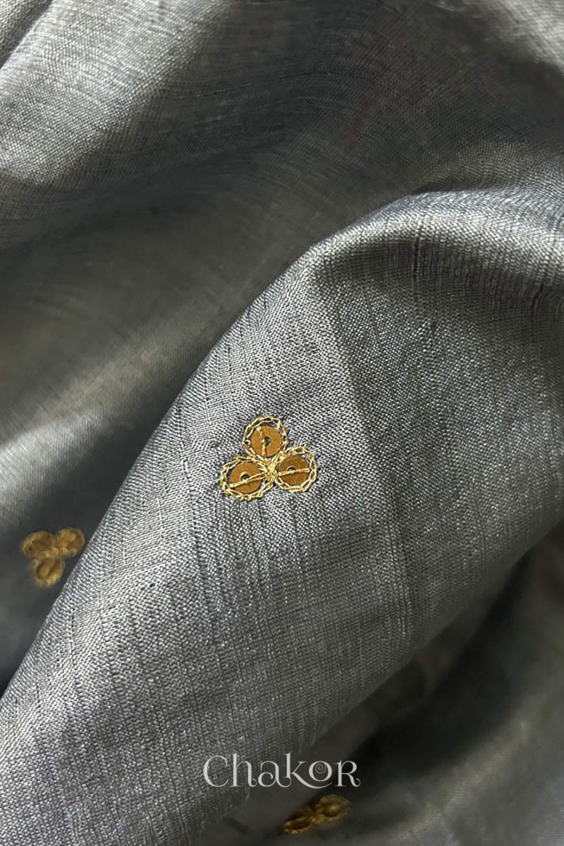 Close up of Grey tussar silk handloom saree with golden zari border & hand embroidered with  sequins & zari work