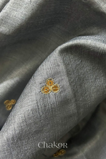 Close up of Grey tussar silk handloom saree with golden zari border & hand embroidered with  sequins & zari work