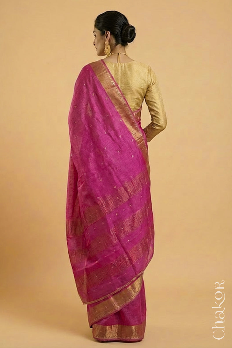 back pose of Woman wearing a Pink tussar silk handloom saree with golden zari border & hand embroidered with  sequins & zari work