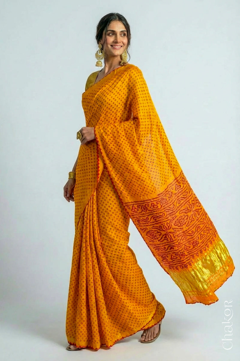 Woman wearing Handcrafted Yellow Bandhani Gaji Silk Saree, traditional rai bandhej patterns in red dots embellished with mirror and sequins embroidery.