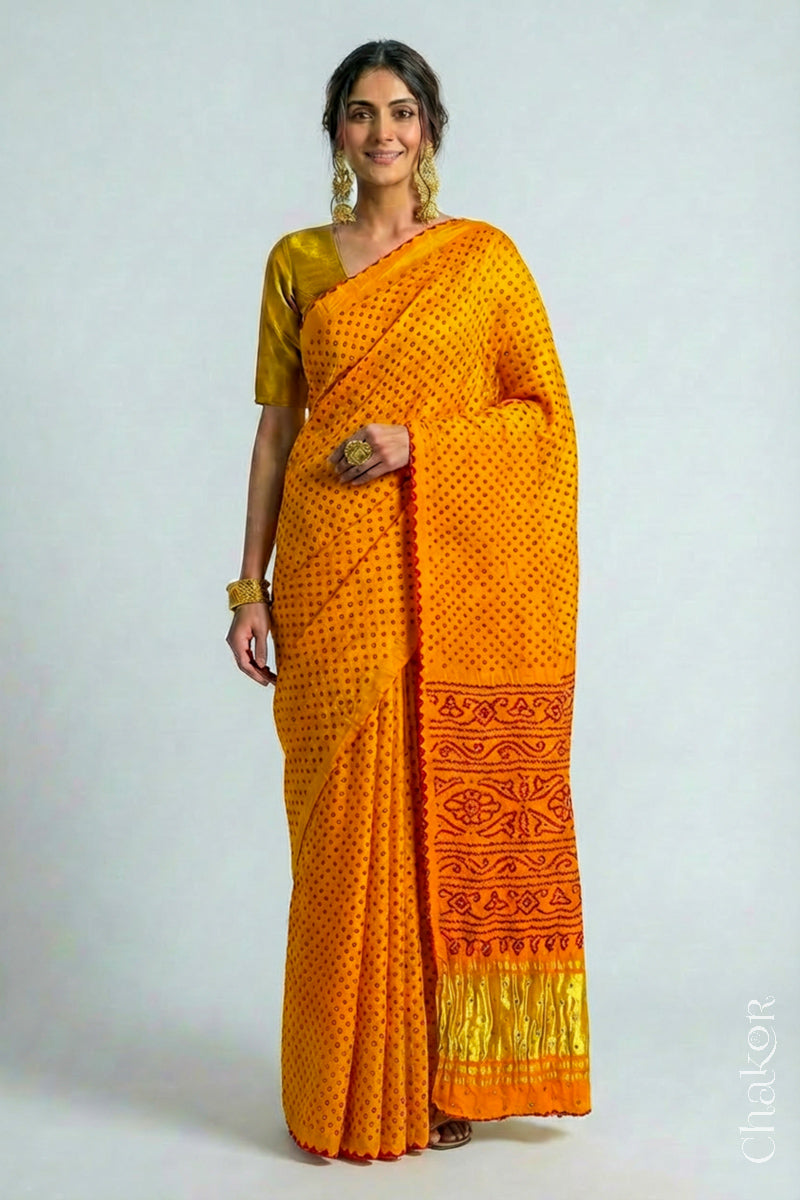 Woman wearing Handcrafted Yellow Bandhani Gaji Silk Saree, traditional rai bandhej patterns in red dots embellished with mirror and sequins embroidery.