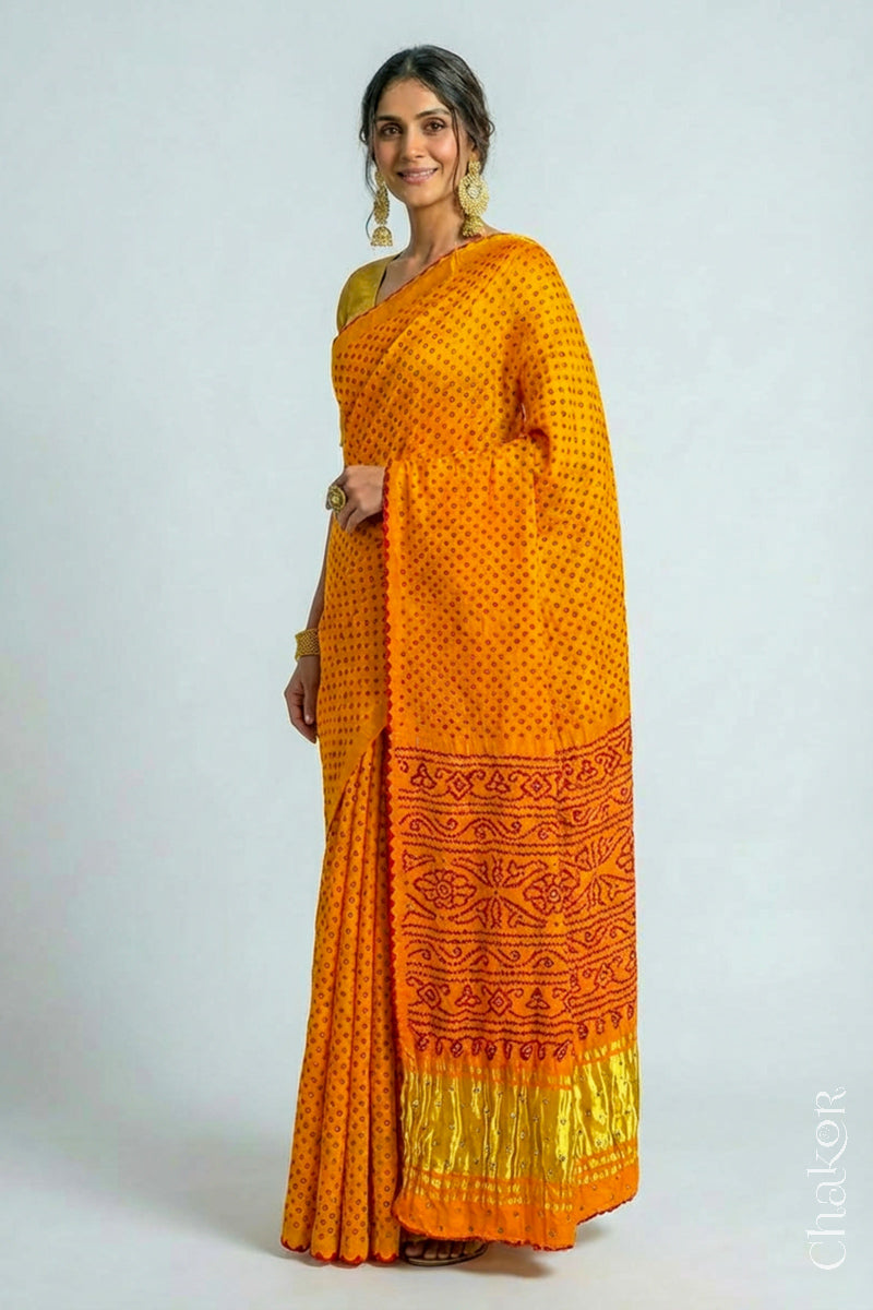 Woman wearing Handcrafted Yellow Bandhani Gaji Silk Saree, traditional rai bandhej patterns in red dots embellished with mirror and sequins embroidery.