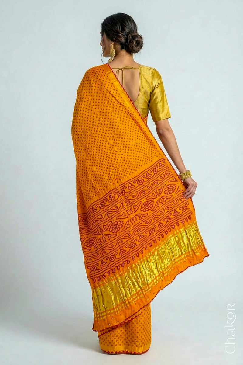 Woman wearing Handcrafted Yellow Bandhani Gaji Silk Saree, traditional rai bandhej patterns in red dots embellished with mirror and sequins embroidery.
