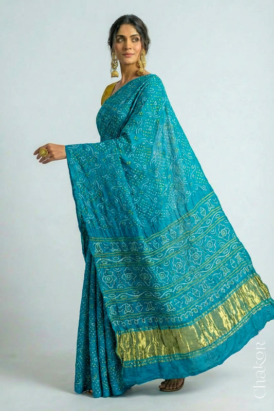 Woman wearing Hancrafted Peacock Blue Bandhani Gaji Silk Saree, with traditional rai bandhej patterns and mukaish embroidery.
