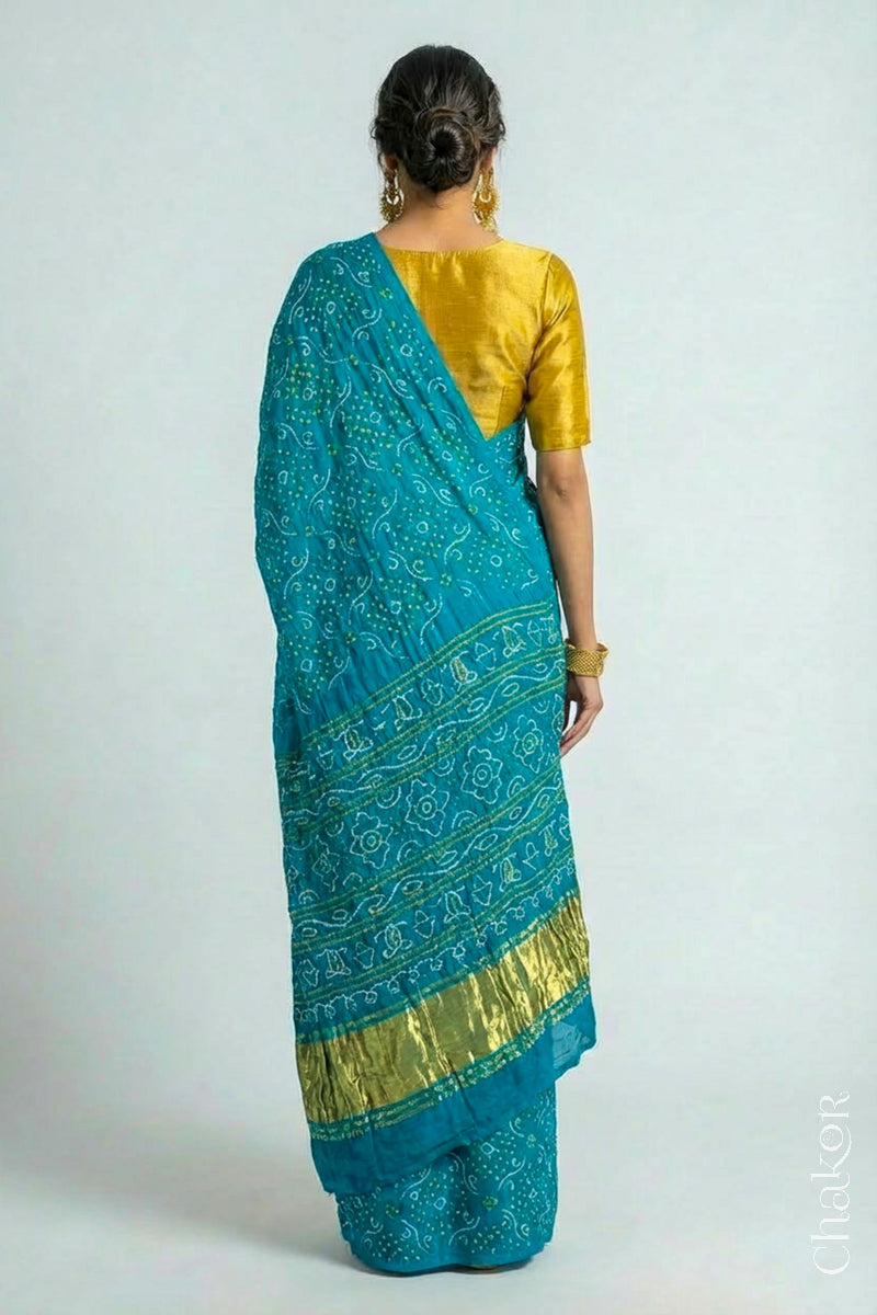 Woman wearing Hancrafted Peacock Blue Bandhani Gaji Silk Saree, with traditional rai bandhej patterns and mukaish embroidery.